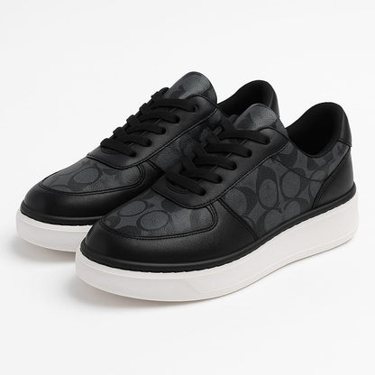 Black leather sneakers with subtle patterned sides and white sole – stylish and comfortable casual shoes for women.